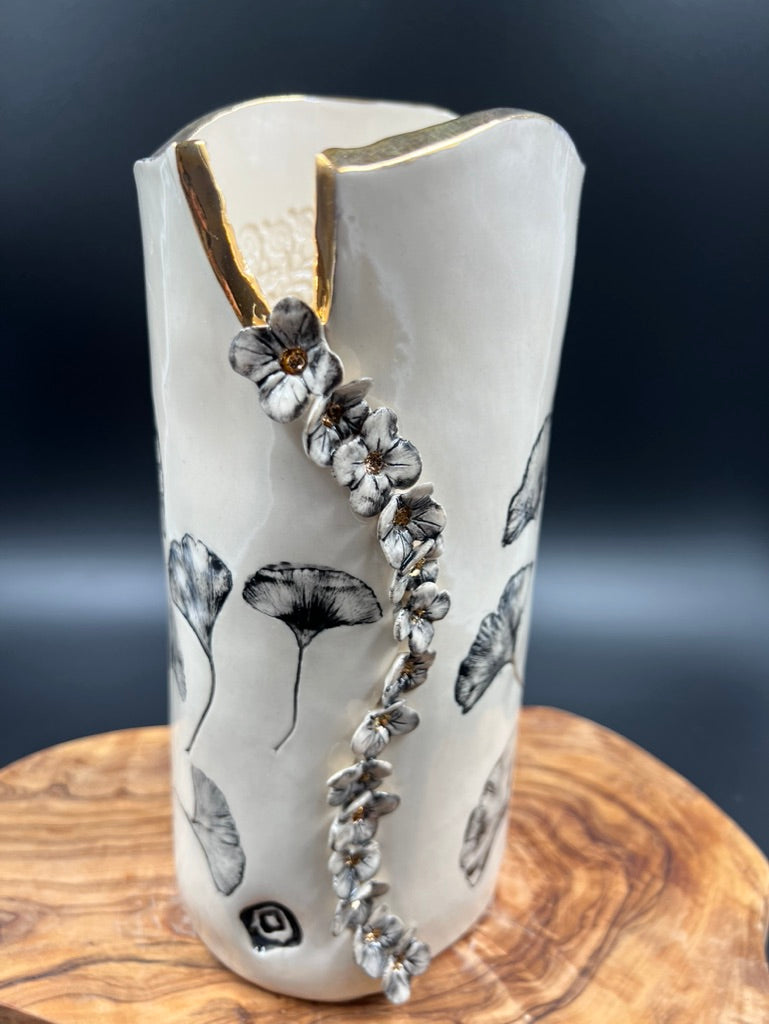 Black floral vase, gold rim, cascading flowers