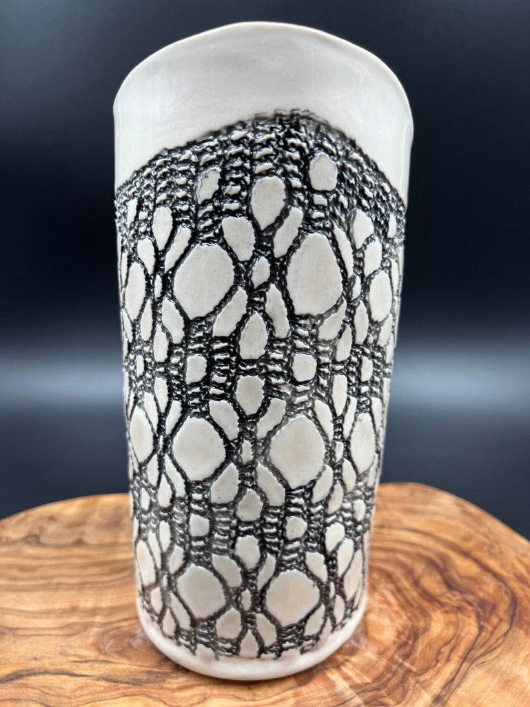 Black lace vase with flower at lip and black interior lace
