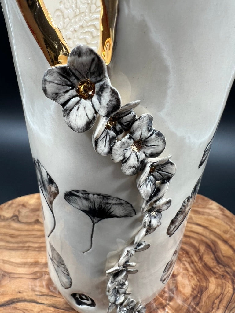 Black floral vase, gold rim, cascading flowers
