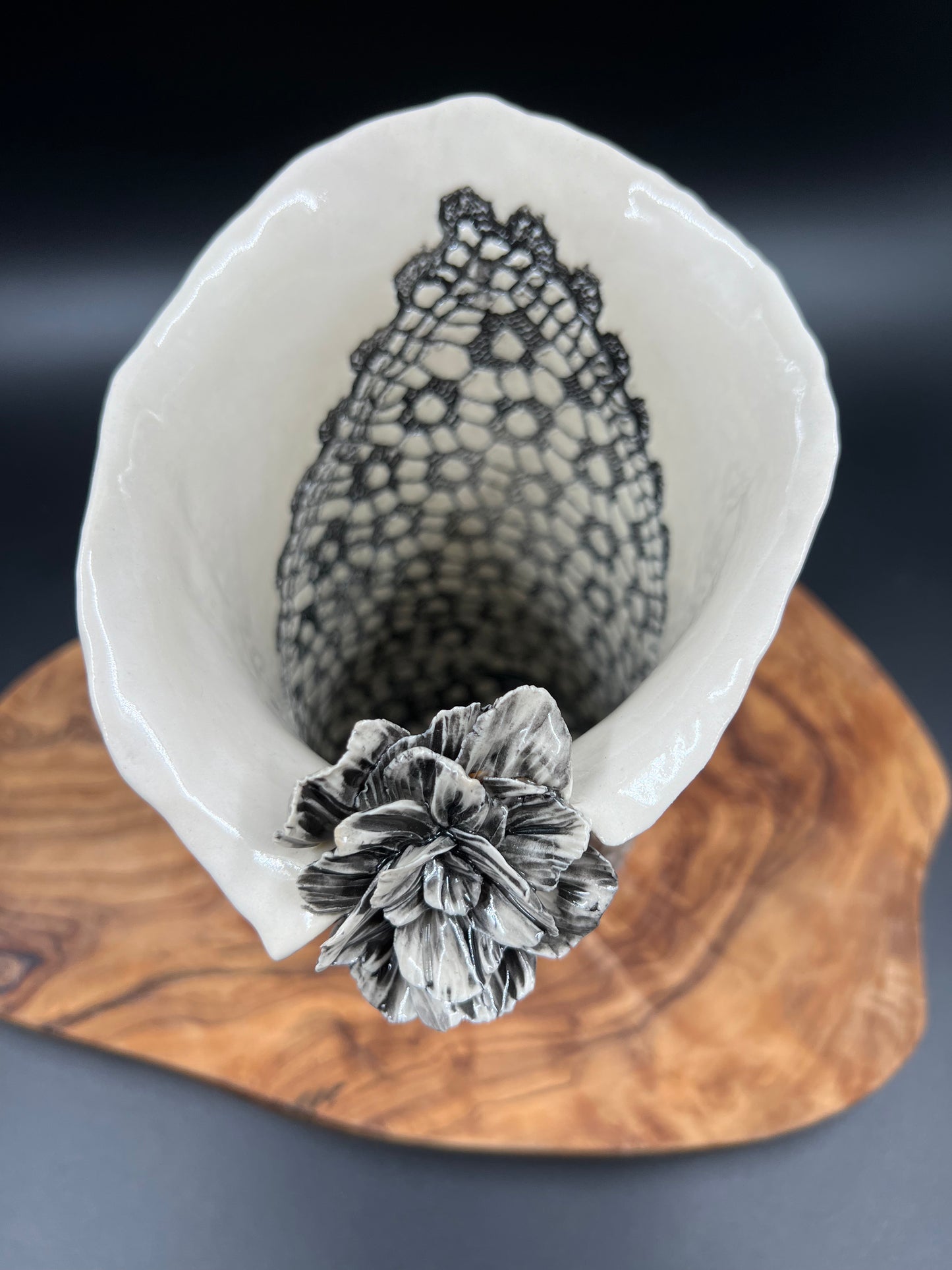 Black lace vase with flower at lip and black interior lace