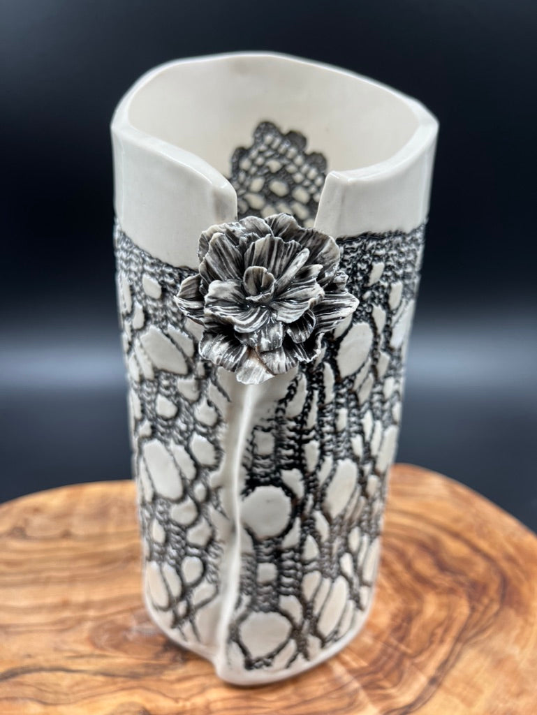 Black lace vase with flower at lip and black interior lace