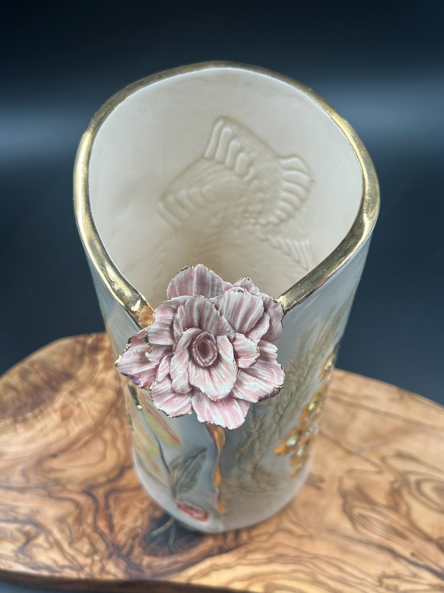 Color floral vase with light pink flower at lip and gold rim