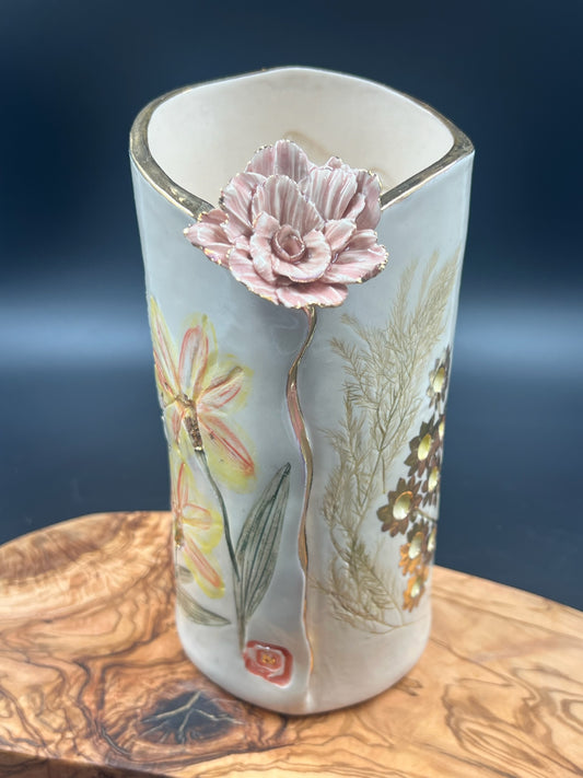 Color floral vase with light pink flower at lip and gold rim